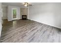 A bright living room with a cozy fireplace, neutral walls, and durable flooring at 517 Hidden Cellars Dr, Holly Springs, NC 27540