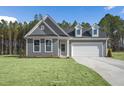 Beautiful gray home with dormer windows, two-car garage, and a spacious lawn at 545 Beacon Hill Rd # 32, Lillington, NC 27546