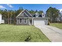 Inviting gray home with dormer windows, two-car garage, and well-maintained front yard at 545 Beacon Hill Rd # 32, Lillington, NC 27546