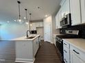 Beautiful kitchen featuring stainless steel appliances, quartz countertops, and pendant lights over the island at 604 Hyperion Aly, Wake Forest, NC 27587