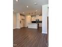 Open concept living room and kitchen featuring modern lighting, sleek floors, and a functional kitchen island at 604 Hyperion Aly, Wake Forest, NC 27587
