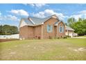 Brick house featuring a well-manicured lawn and a driveway leading to a two-car garage at 6042 Elliott Bridge Rd, Linden, NC 28356