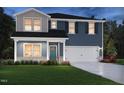 Charming two-story home featuring blue siding, a white garage door, and a cozy front porch at 677 White Birch Ln, Angier, NC 27501