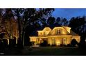 Beautiful home exterior with manicured lawn and landscape lighting at night at 7400 Portpatrick Ct, Wake Forest, NC 27587