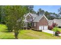 Charming brick two-story home featuring an attached two-car garage and beautifully landscaped front yard at 7405 Pine Summit Dr, Fuquay Varina, NC 27526