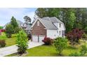 A beautiful two-story home with a brick and vinyl exterior, attached two-car garage, and driveway at 7405 Pine Summit Dr, Fuquay Varina, NC 27526