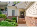 Cozy front porch with brick steps, surrounded by lush greenery and leading to the welcoming front door at 7705 Astoria Pl, Raleigh, NC 27612