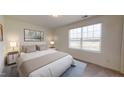 Bright bedroom featuring neutral walls, carpeted floors, a large window, and furnishings with modern lamps at 914 Bombardier Aly, Spring Hope, NC 27882
