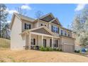Attractive two-story home showcasing a charming front porch, well-maintained siding, and a neatly manicured lawn at 1009 Haynoke Dr, Graham, NC 27253
