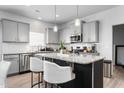 Modern kitchen featuring gray cabinets, stainless steel appliances, granite countertops, and a central island at 1009 Haynoke Dr, Graham, NC 27253