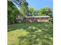 Charming brick home with green shutters and a well-maintained lawn at 1102 Parkwood Dr, Siler City, NC 27344