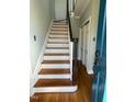 View of hardwood entry stairs with the front door open at 112 Hilton Ave, Durham, NC 27707