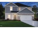 Charming home exterior featuring a gray siding, stone accents, and a two-car garage at 1139 Winding Spring Dr, Mebane, NC 27302