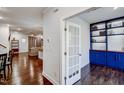 Hallway view that flows into the living room, showcasing hardwood floors and a bonus room with custom shelving at 124 Shale Creek Dr, Durham, NC 27703