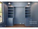 Built in shelving units with cabinets in a home office painted a lovely shade of blue at 12845 Mallard Rock Rd, Zebulon, NC 27597