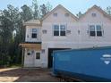 New two-story home showcasing its facade with large windows and attached garage, during construction at 15 Calluna Dr, Clayton, NC 27520