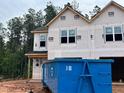 New construction featuring a modern exterior design with large windows, creating an inviting curb appeal in a wooded setting at 15 Calluna Dr, Clayton, NC 27520