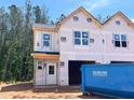Exterior view of a new construction home featuring a blue dumpster ready for construction debris at 15 Calluna Dr, Clayton, NC 27520