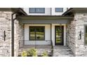 Inviting front porch with stone accents and a modern, sleek door at 200 Broadleaf Ln, Youngsville, NC 27596