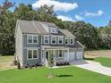 Charming two-story home with gray siding, white trim, large windows, covered porch, and three-car garage at 203 Great Smoky Pl, Lillington, NC 27546