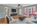 Comfortable living room featuring hardwood floors, a neutral color scheme, large screen TV, and bay windows at 205 Lizzie King Ct, Willow Springs, NC 27592