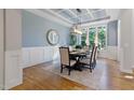 Elegant dining room with natural light, a stylish chandelier, and beautiful hardwood floors at 211 Page St, Morrisville, NC 27560