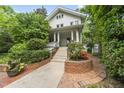 Beautiful white two-story home featuring lush greenery and an inviting brick-lined walkway to the front entrance at 223 Hawthorne Rd, Raleigh, NC 27605