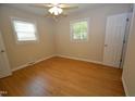 Cozy bedroom with hardwood floors, ceiling fan, two windows letting in natural light, and neutral-colored walls at 2805 Nc 55, Durham, NC 27713