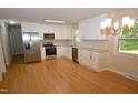 Modern kitchen boasts stainless steel appliances, granite countertops, white cabinets, and hardwood floors at 2805 Nc 55, Durham, NC 27713