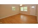 Inviting living room featuring gleaming hardwood floors, a ceiling fan, and abundant natural light from multiple windows at 2805 Nc 55, Durham, NC 27713