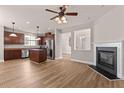 Open-concept living space with a modern fireplace, wood floors, and stainless steel appliances in the kitchen at 3002 Remington Oaks Cir, Cary, NC 27519