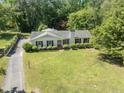 Aerial view of a white ranch-style home with mature trees and a long, paved driveway at 306 Holland Rd, Fuquay Varina, NC 27526