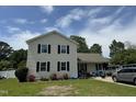 Two-story home with cream siding, black shutters, and a boat parked in the driveway at 309 Westfield Dr, Dunn, NC 28334