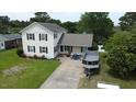 Two-story home with cream siding, black shutters, and a boat parked in the driveway at 309 Westfield Dr, Dunn, NC 28334