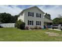 Two-story home with cream siding, black shutters, and a boat parked in the driveway at 309 Westfield Dr, Dunn, NC 28334