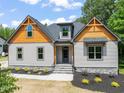 Home exterior with welcoming entrance, showcasing stone accents, trimmed shrubs, and an appealing design at 310 Pilot Ridge Rd, Zebulon, NC 27597