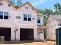Image of new construction home with unfinished exterior, two-car garage, visible windows, and wild logo at 33 Calluna Dr, Clayton, NC 27520