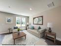 Staged living room with neutral colors and plenty of natural light at 33 Calluna Dr, Clayton, NC 27520