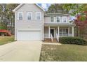 Charming two-story home with a white picket porch, attached garage, and manicured lawn at 338 Howland Ct, Creedmoor, NC 27522