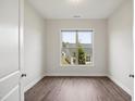 Light-filled bedroom with wood floors and a large window offering natural light and neighborhood views at 3510 Tuftonboro Ln, Apex, NC 27502