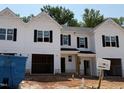 New construction townhome with white siding, black shutters, and an attached two-car garage at 45 Calluna Dr, Clayton, NC 27520