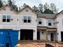 Unfinished two-story home with visible construction elements and a two-car garage at 45 Calluna Dr, Clayton, NC 27520