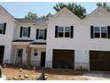 Newly constructed townhouse with white siding, black shutters, and attached garages at 51 Calluna Dr, Clayton, NC 27520