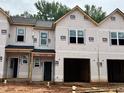View of new construction townhomes featuring attached garages and an unfinished yard at 51 Calluna Dr, Clayton, NC 27520