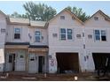 New townhomes show a modern design with multiple windows and attached garages in an active construction zone at 51 Calluna Dr, Clayton, NC 27520