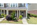 Inviting townhome porch with charming brickwork, decorative plants and clear address signage at 520 Austin View Blvd, Wake Forest, NC 27587