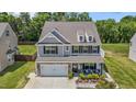Charming two-story home with grey siding, a two-car garage, and a cozy front porch with outdoor seating at 528 Brycewood Dr, Burlington, NC 27215