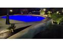 Backyard pool with in-ground lighting, surrounded by manicured landscaping and a privacy fence at 528 Brycewood Dr, Burlington, NC 27215