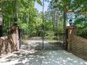 Impressive black iron entrance gate with brick pillars and mature trees at 5420 Deer Forest Trl, Raleigh, NC 27614