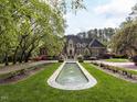 Stately brick home with manicured lawn, fountain, and lush landscaping at 5420 Deer Forest Trl, Raleigh, NC 27614